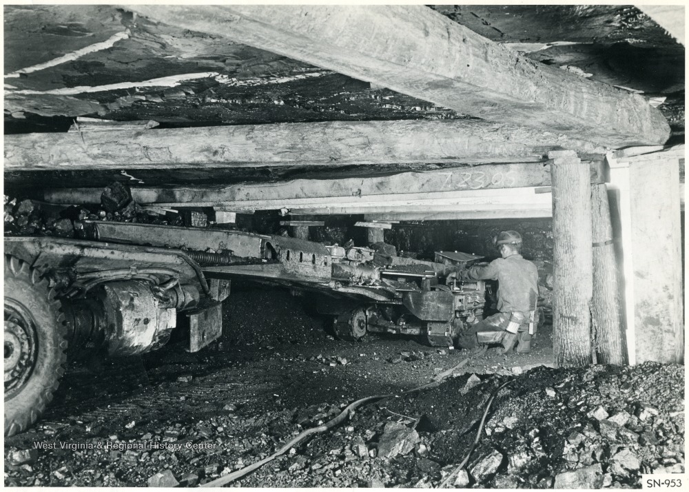 A miner operating a coal cutting machine.
