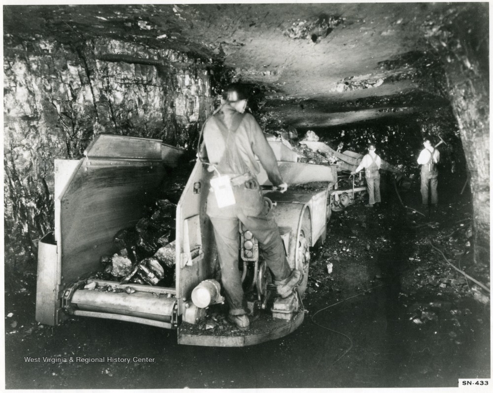 Miners at work with loading machine and shuttle car.