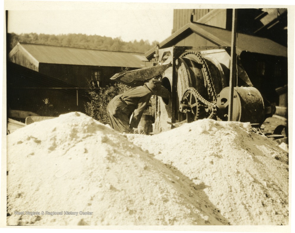 A miner working with machinery on the exterior of a mine.