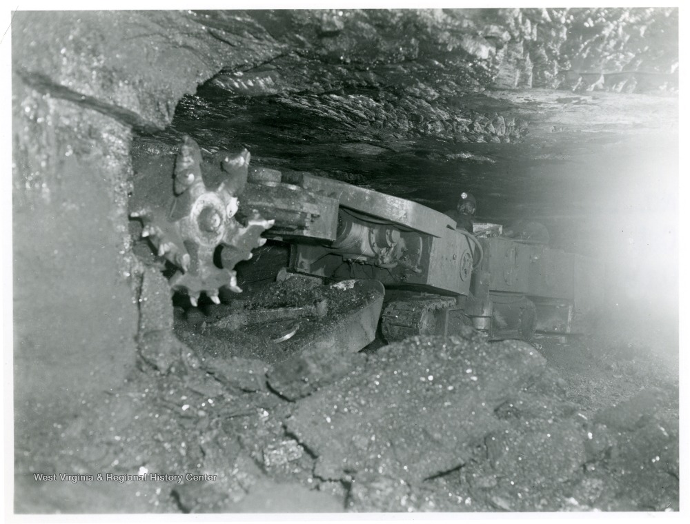 Miner using machine to cut coal.
