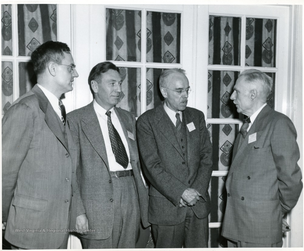 Dean Van Liere is standing on the right and President Stewart is standing on the left, with two unidentified men standing between.