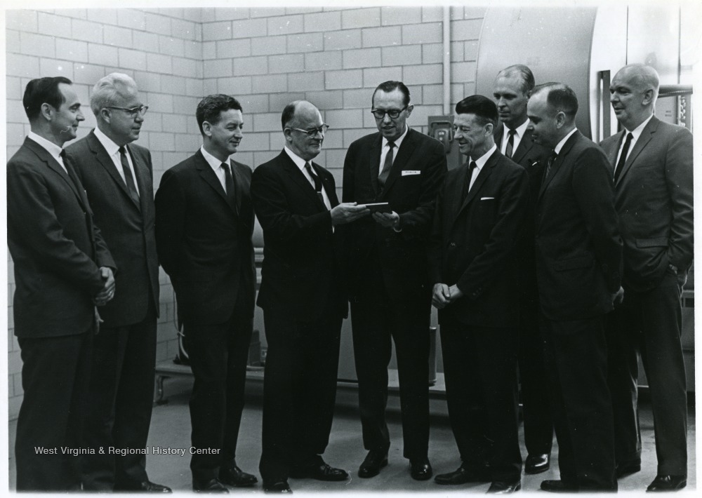 A group portrait of Paul Kent (far left), Butler (second from left), Harry Heflin (third from left), Robert Sloneger (second from right), Don Holland (third from right), and C.A. Arents (center).