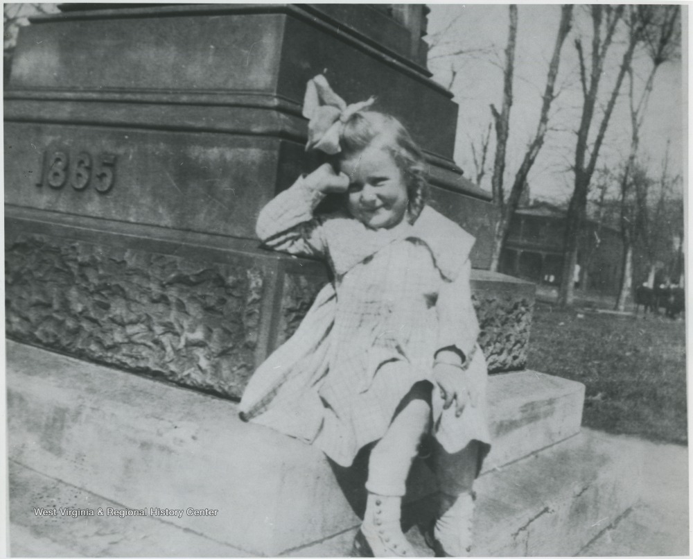 Kathleen Timberlake pictured leaning against the monument located at Court House Square. The Miller Hotel can be seen in the background. 