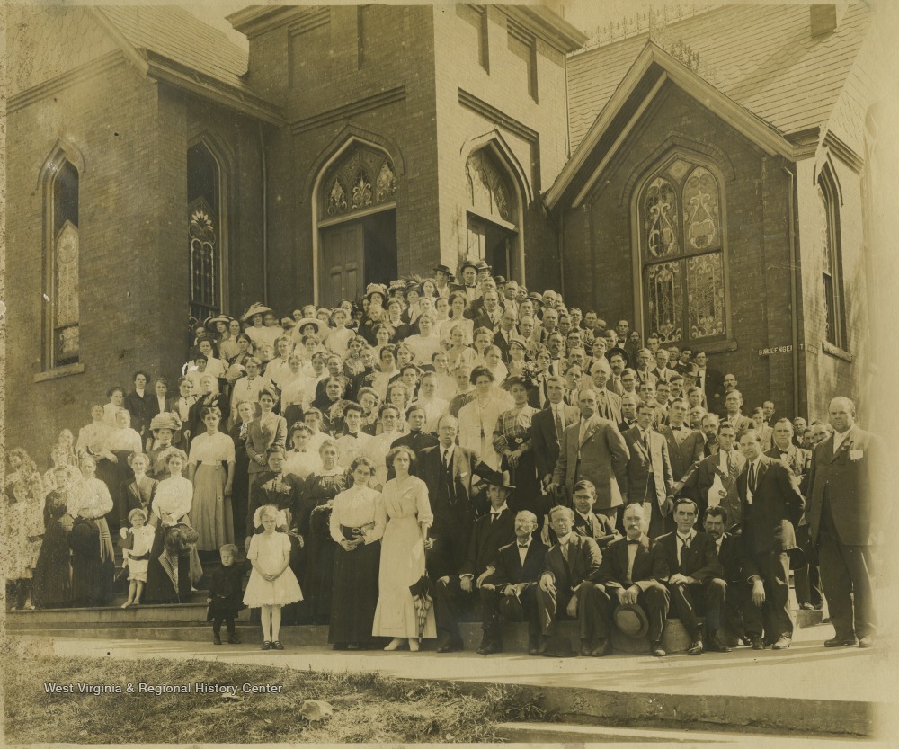 Located on the corner of 3rd Avenue and Ballengee Street, a group of church members pose in front of the building and on the steps. The reverend at the time the picture was taken was Rev. Gates. Subjects unidentified. 