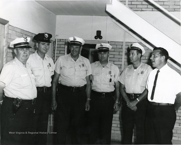 From left to right: 'Police Chief John Lewis, William Musgrave, Bill Hughes, Bennie Palmer, George Katchur, Robert West'. 
