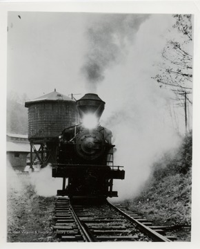 Locomotive traveling down tracks.