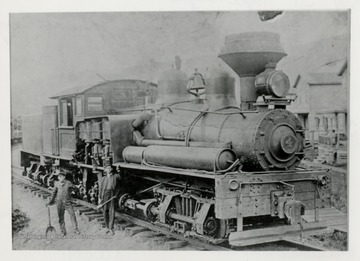 Train engine with two men beside of it.  