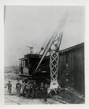 Crew members pose in front of ditcher. 
