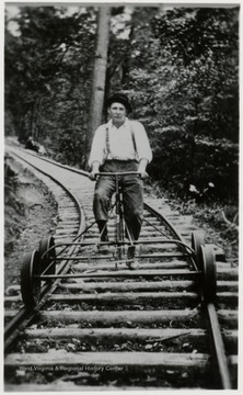 Man riding a speeder on a train track.  