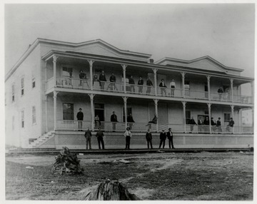 Hotel at Cass showing several men on the porches and on the ground.  Front view.