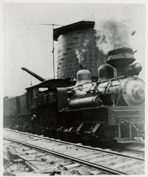 3/4 front view of Shay No. 13 train engine at a water tank.