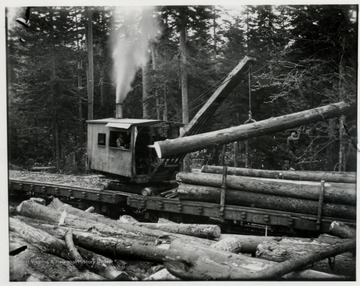 Loader placing logs onto a Greenbrier and Elk Car.