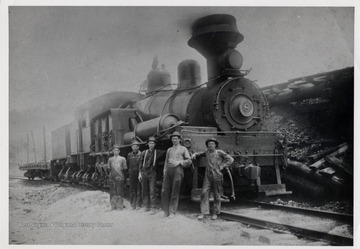 3/4 front view of Shay train engine No. 8.  Five men standing beside the train engine.