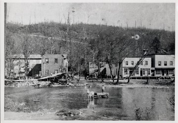 Business section of Cass, W.Va.  Cass wagon fording river.  Swinging bridge on the side.