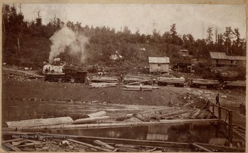 The Jacob L. Rumbarger Lumber Company Shay No. 1 hauling log cars. Crew rolls logs into the water from the train.