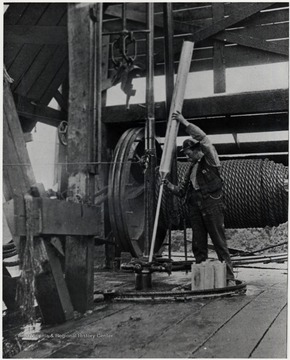 Man working with a piece of oil machinery.