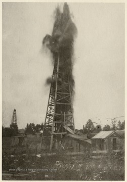 Large amounts of oil shooting out of a derrick after being shot with nitroglycerin.