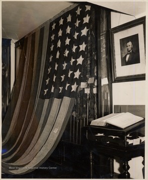 Old American Flag hanging on a wall beside a picture of Abraham Lincoln.The Flag was hand sewn in Shepherdstown within days of West Virginia's creation on June 20, 1863. It is one of only a few 35-star flags in existence. The 35-star flag was in use for only three years, and during most of its lifespan was not recognized by the southern states represented among its stars.<br />