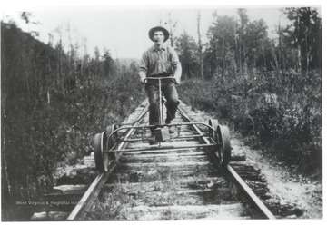 Man riding a speeder on a train track.
