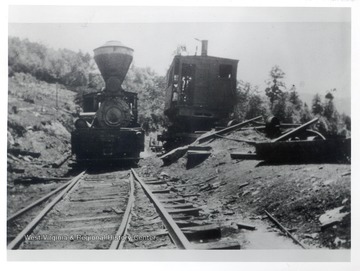 Train engine on tracks moving past a railroad spill.