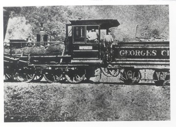 Side view of Georges Creek train engine and two crew members.