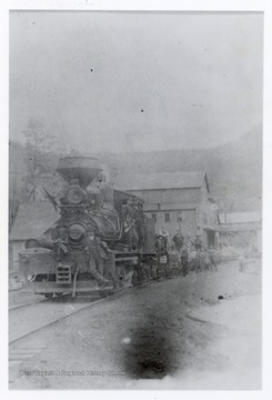 Crew workers standing with a train engine.