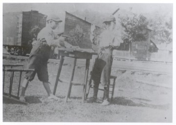 Herman Teter (with pistol) and Virgil Layman playing gamblers after going to D.K. Teter's picture show about 1913.  Appears on p.6 of 'Goin' Up Gandy'.