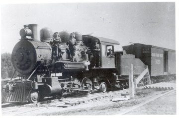 Locomotive on tracks with crew posing on the engine.