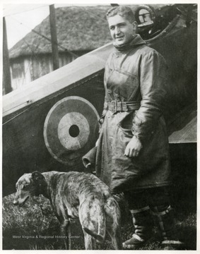 Lt. Louis Bennett, Jr. and dog standing in front of S. E. 5a airplane.