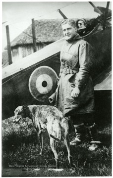Lt. Louis Bennett, Jr. and dog standing in front of a S. E. 5a airplane.