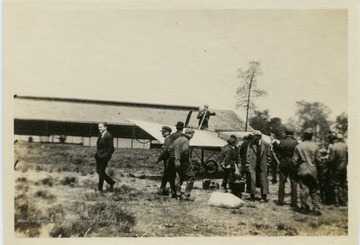 Louis Bennett, Jr. walks away from the group and airplane at Sheepshead Bay.  The airplane appears to be a Bleriot monoplane.