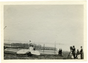 Louis Bennett, Jr. and others stand to the right of an airplane while waiting for his 'tryout.'  The aircraft appears to be an early Curtiss JN ("Jenny").