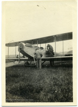 Men inspect Louis Bennett, Jr.'s airplane 'after the fall.'  Photograph taken at 9 a.m. on Sunday, May 27th, 1917 at Sheepshead Bay.  The aircraft is a Curtiss JN-4 ("Jenny").