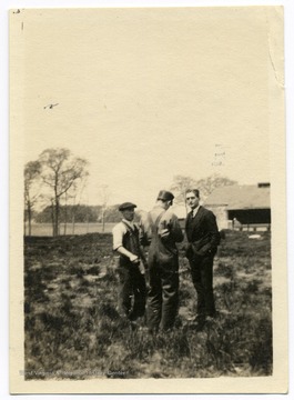 Louis Bennett, Jr. and two men stand in field at Sheepshead Bay.