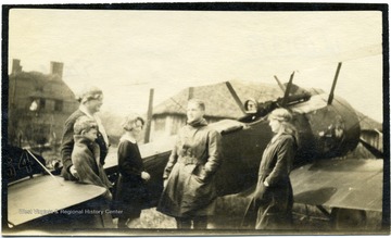 Louis Bennett, center, stands among friends next to airplane.  Names listed on back are Ethel Mills, Mordaunt, Ottilie, and Verity.  Portrait of Lt. Louis Bennett, Jr., R.F.C.  This photograph, as well as others (numbers 001378, 001379, and 001380) are referenced in a letter from Mrs. Ethel Mills to Mrs. Louis Bennett, Sr. The text of the letter is as follows: August 20, 1919 Drokes, Beaulieu, Hants My Dear Mrs. Bennett, I just want to reach across the channel, and take your hand and hold it, in a great understanding silence! To begin with, you could not have had my address if your dear boy had not given it!  I hope you will be coming to England [and] will come to us for a few days.  And get to know his old surroundings here -- where he lived [and] bunked.  I remember I was at work building a pig stye! -- when suddenly he appeared flying round [and] round my house and suddenly he made the most beautiful desent [sic] and stood before us, with his handsome face glowing, 'I’ve come to say good bye' -- he could only stay for ½ an hour -- and we mutually photographed each other -- then he was gone, saying 'I’ll send back my photo for you all to sign.'  He had no sooner gone, than I grieved I hadn’t asked him for your address, so as to send you any of ours that might be good, as I knew how you’d love to have as many snapshots as possible, but hoped I’d soon hear from him.  Well at last I did write -- the photo I had to wait sometime to get a signature -- [and] something made me write to him without returning him his [and] ours --  fearing he had moved from his last address -- so I said do tell me if this reaches you before I send the precious photos.'  And I waited, [and] as time passed, I feared he had gone to join with those other warriors!  Then came the trying to find you, [and] send you these precious snapshots. [and] so when I saw your envelope, before I opened it, or had even turned it round, I knew what its contents must be [and] I just felt greatful that evidently he looked upon us as friends, [and] so had given you my name and address.  You will let me see you should you come to England won’t you -- [and] if possible you will come down to Bealieu [and] be with us for a little while. I will not write more tonight -- but with true love [and] the deepest sympathy to Mr. Bennett and yourself. Yours affectionately Ethel Mills You will want his letter too.  You will see the fine way he agitated to get to France and to be fighting!