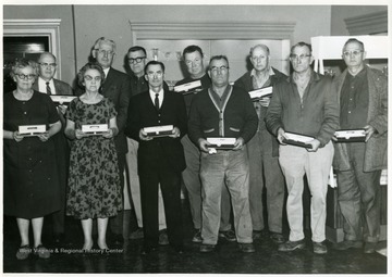Group portrait of glass workers. From left to right, Front Row: Della Burckett, Cythia Dunlap, Bruce Montgomery, Albert Wheeler, Floyd Carney, Cecil Coffield; Back Row: Eldon Fox, Michael Grubber, Orville Bickerton, Norman Greenan, James Pelley.