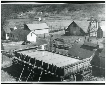 Aerial view of the salt works with salt water reserve tank in the foreground and surrounding buildings.