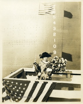 Mann is pictured with a bouquet of roses in front of the ship. 