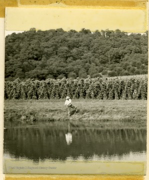 Farm pond on the A.H. Hillyard farm with a man casting his fishing line.  Caption reads, 'Farm ponds are still increasing.  This one on the A. H. Hillyard Farm not only provides excellent fishing but water supply for irrigating vegetables as well. (Benton Hazellat, Chairman North Panhandle Soil Conservation District)'