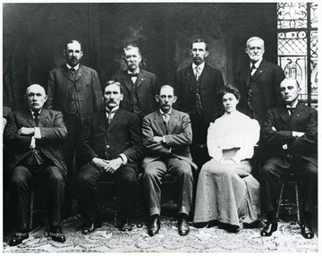 1. Abraham McCullough, President, Wheeling; 2. R.E. Thrasher, Lewisburg; 3. John B. Garvin, Secretary, Charleston; 4. M.V. Brown, Buffalo (Putnam Co.); 5. E.J. Humphrey, Belleville; 6. W.D. Zinn, Philippi; 7. Irene C. Dick, Stenographer, Charleston; 8. H.A. Hartley, Masontown; 9. Charles P. Light, Martinsburg; Rear, Left to Right - Thrasher, Brown, Zinn, Hartley; Front, Left to Right - McCullough, Garvin, Humphrey, Dick, Light.<br />