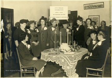 A group portrait of the Randolph County Farm Women's Council, 1923-1944, standing and sitting around a table.