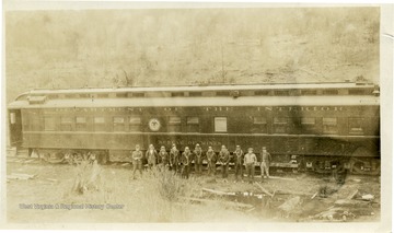 Group portrait taken at Thomas, W. Va. of a group of miners standing next to a Department of the Interior Bureau of Mines Train.