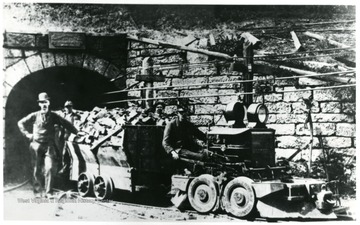 Miners standing next to coal carts and a locomotive. John Williams/Coal Life Project.