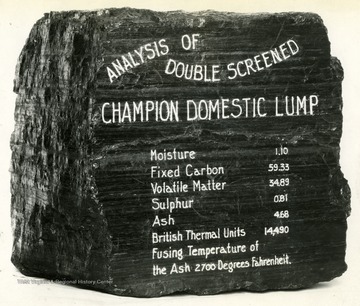 Large piece of coal with Analysis of Double Screened Champion Domestic Lump written on the side. 