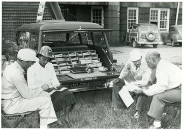 Group of miners looking over documents. 