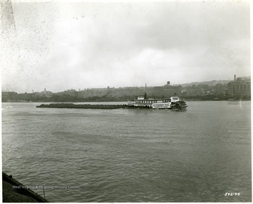 Pittsburgh Coal Co. towboat with a load of coal outside of an unknown city.