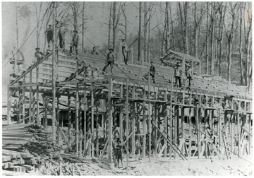 Workers construct the wooden frame for a company store.