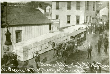 Street scene after Monongah disaster. Horse-drawn hearse delivers caskets to the mine and coffins line the street of Monongah.
