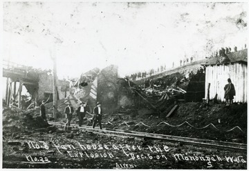 Men standing outside and inside of the demolished fan house.