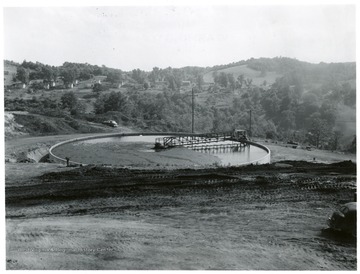 Thickener and settling tank with houses in the background.
